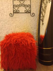 a red furry rug next to a bottle of wine at In House in Tbilisi City