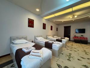 a room with four beds and a flat screen tv at Узбечка in Tashkent