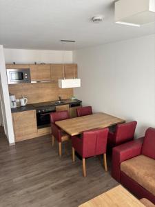 a kitchen and dining room with a wooden table and red chairs at Apartment 117 in Feldberg
