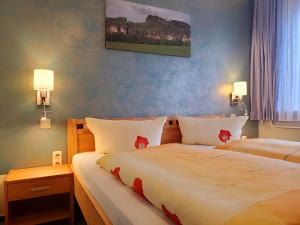 a bedroom with two beds and two lamps on the wall at Pension Am Nationalpark in Stadt Wehlen