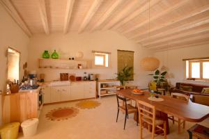 a kitchen and living room with a wooden table and a dining room at Casa Imayah charming B&B in Noto