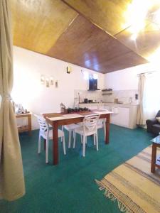 a dining room with a wooden table and white chairs at Meis cottage Umpling in Shillong