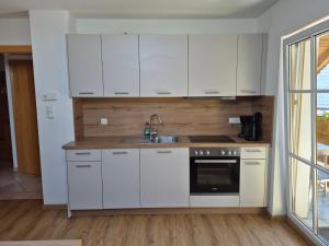 a kitchen with white cabinets and a sink at Ferienhof Edtmeier in Zell am Moos
