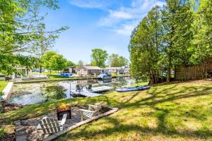 a backyard with a fire pit and boats in the water at Romantic A-frame HeartJacuzzi Firepit Kayaks in Warsaw