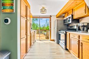 a kitchen with wooden cabinets and a door leading to a deck at Romantic A-frame HeartJacuzzi Firepit Kayaks in Warsaw