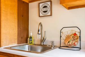 a kitchen counter with a sink and a kitchen sign on the wall at Romantic A-frame HeartJacuzzi Firepit Kayaks in Warsaw +20 photos