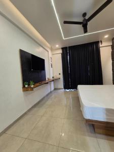 a bedroom with a bed and a flat screen tv at Omex hazratganj arjunganj in Nalmatha +5 photos