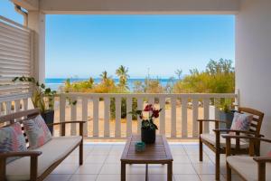 a balcony with a table and chairs and the ocean at Le chant du Lagon in La Saline les Bains