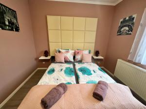 a bedroom with a bed with two pillows on it at Dorina Wellness Apartman in Siófok