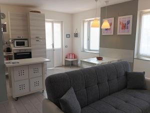 a living room with a couch and a kitchen at Casa Mariuccia in Valledoria