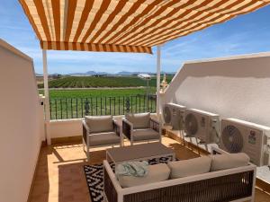 a patio with a couch and chairs on a balcony at Casa Teuwisse in Torre-Pacheco