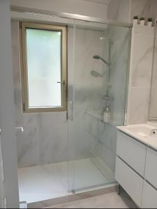 a bathroom with a glass shower and a sink at La Précieuse, RER A Proche Paris in Saint-Maur-des-Fossés