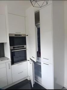 a kitchen with white cabinets and an oven at La Précieuse, RER A Proche Paris in Saint-Maur-des-Fossés