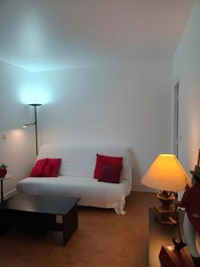a living room with a white couch with red pillows at La Précieuse, RER A Proche Paris in Saint-Maur-des-Fossés