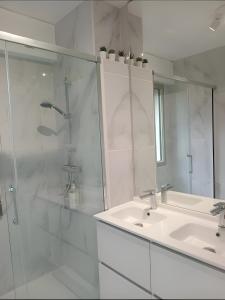 a white bathroom with a shower and a sink at La Précieuse, RER A Proche Paris in Saint-Maur-des-Fossés
