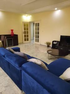 a living room with a blue couch and a table at Grand et chic appartement in Dakar +8 photos