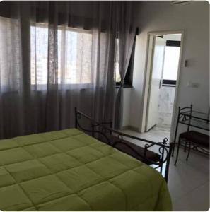 a bedroom with a green bed and a window at Grand et chic appartement in Dakar
