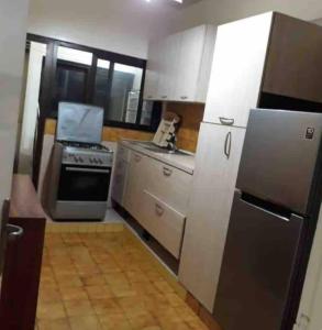 a small kitchen with a stove and a refrigerator at Grand et chic appartement in Dakar
