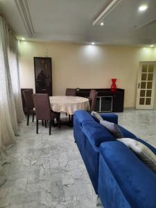 a living room with a blue couch and a table at Grand et chic appartement in Dakar
