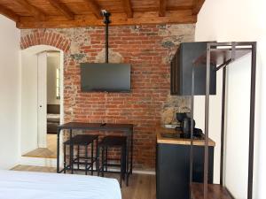 a kitchen with a table and a brick wall at Palazzo Garbusi in Sarzana