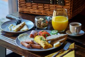 a table with a plate of breakfast food and a glass of orange juice at Novosiele Residence - nad górską rzeką - Leśne Spa sauna jacuzzi - Bieszczady in Bystre +66 photos