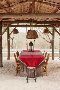 a table in a pavilion with a red table cloth at The Island Houses Gili Meno in Gili Meno
