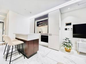 a white kitchen with a bar and a tv at 서초 아트하우스2 in Seoul