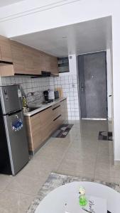 a kitchen with a stainless steel refrigerator and wooden cabinets at Serene Studio near UN headquarters and Gigiri in Ruaka