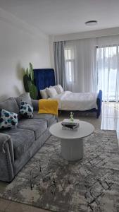 a living room with a couch and a table at Serene Studio near UN headquarters and Gigiri in Ruaka