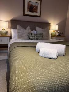 a bedroom with a large bed with two pillows at The Hare and Hounds in Fulbeck