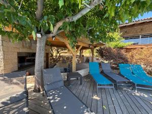 a deck with blue chairs and a tree at VILLA Cala D'orzu in Coti-Chiavari