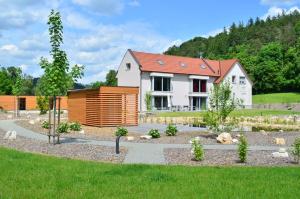 a house with a garden in front of it at Apartmány U Jeskyní in Sloup