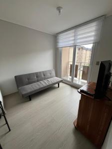 a living room with a couch and a television at Departamento en Villarrica con Piscina y Estacionamiento Privado in Villarrica