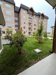 an apartment building with two trees in the yard at Departamento en Villarrica con Piscina y Estacionamiento Privado in Villarrica