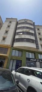 a tall building with cars parked in front of it at فيو المنسك in Abha