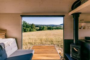 a view of a field from inside a tiny house at Glamping Silverboy in Toužim +5 photos