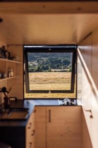 a window in a kitchen with a view of a field at Glamping Silverboy in Toužim