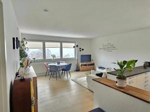 a kitchen and living room with a table and chairs at Ferienwohnung Sunset - Traumhafter Seeblick & Sauna in Steinhude in Wunstorf