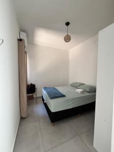 a small bedroom with a bed and a lamp at Beach house in Matinhos in Matinhos