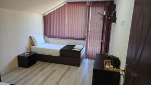 ein kleines Schlafzimmer mit einem Bett und einem Fenster in der Unterkunft Къща Амфора in Trjawna