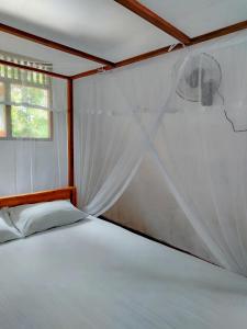 a bedroom with a bed with a mosquito net at Indrasiri Villa Midigama in Kumbalgama