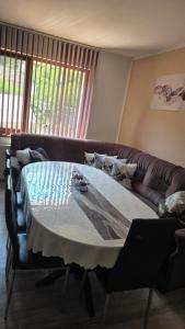 ein Wohnzimmer mit einem Tisch und einem Sofa in der Unterkunft Къща Амфора in Trjawna