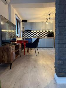 a kitchen with blue cabinets and a red table at Best Apartment Scheia in Suceava