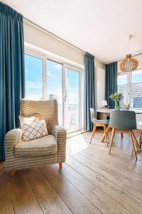 a living room with a chair and a table at Appartement met uitzicht over de Wadden Zee in Oost-Vlieland