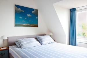 a bedroom with a bed with two pillows at Appartement met uitzicht over de Wadden Zee in Oost-Vlieland