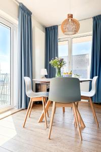 a dining room with blue curtains and a table and chairs at Appartement met uitzicht over de Wadden Zee in Oost-Vlieland +9 photos