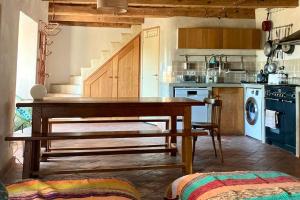 a kitchen with a wooden table with a bench in it at Cévennes et Causse Mejean in Dargilan +15 photos