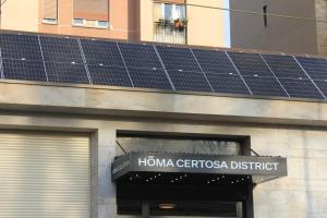 a building with solar panels on top of it at HÕMA Certosa District in Milan