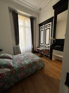a bedroom with a bed and a desk and a piano at Les Cariatides in Lille