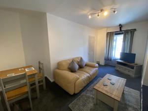 a living room with a couch and a table at Rosecraddoc Manor - Coachman's in Saint Cleer